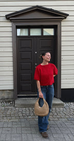Boxy Shortsleeve i rødt, helfigur foran en mørk dør